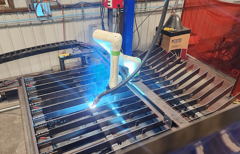The fully automated robotic welding work cell, with all actions orchestrated by an AutomationDirect Productivity PLC, synchronizes the welding process, robot movements, and fixture positioning.