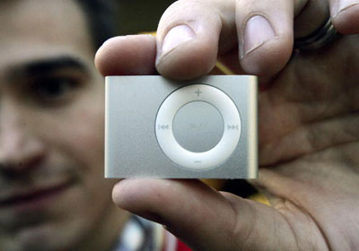 iPod Shuffle比一元硬币大不了多少，是苹果公司生产的精简版MP3播放器。